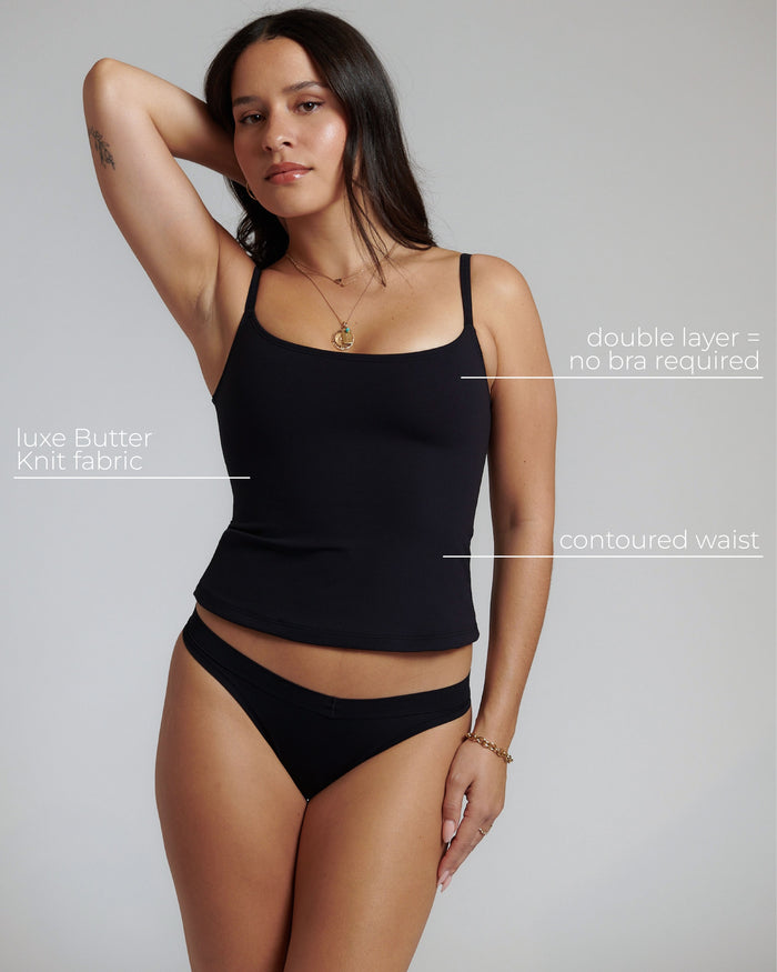 Woman wearing a black cami top with text highlighting features on a gray background