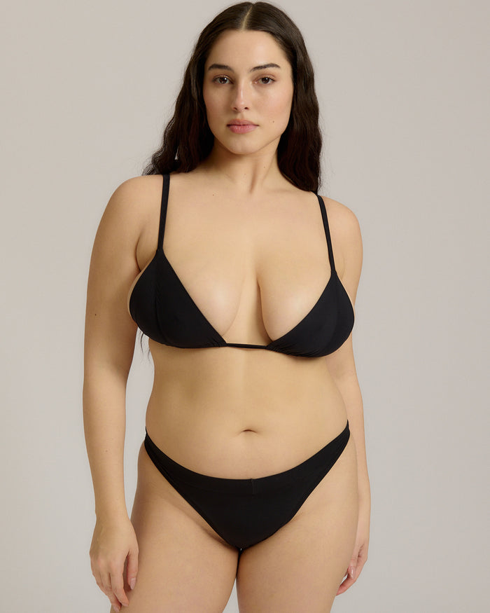 Black triangle bra worn by a model on a plain background