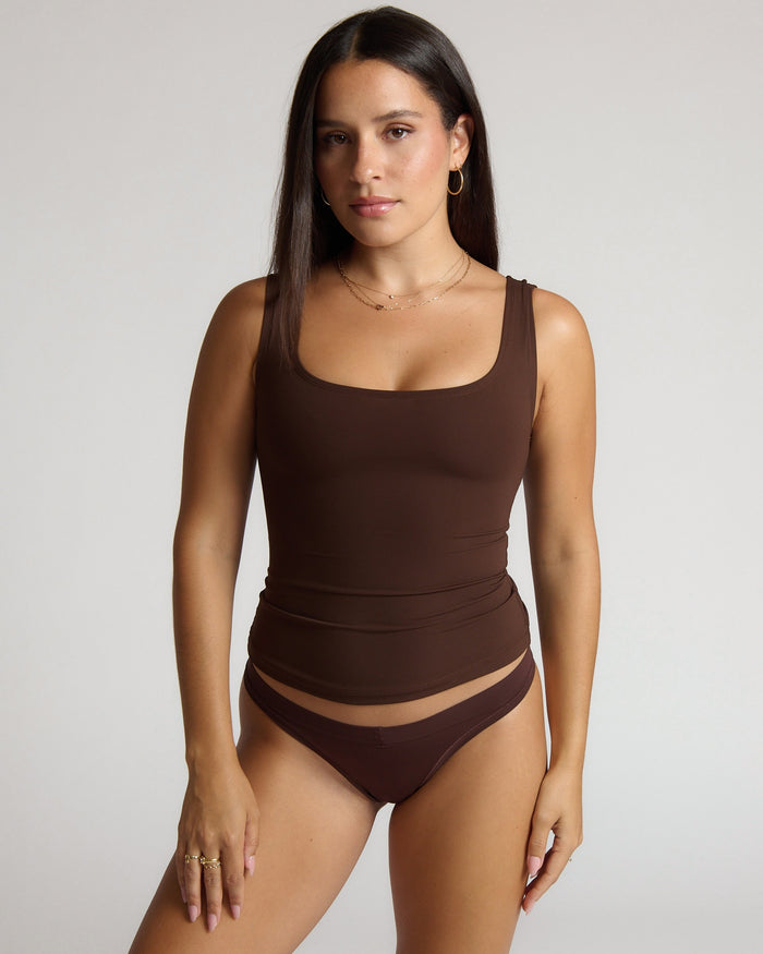 Woman wearing a brown tank top against a white background