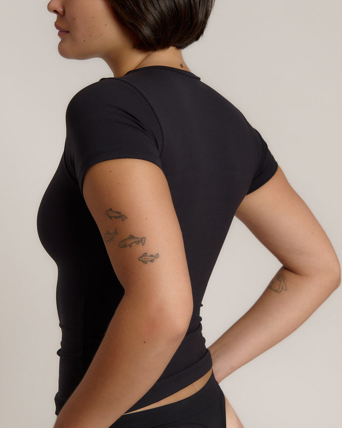 Woman wearing a black t-shirt against a plain background