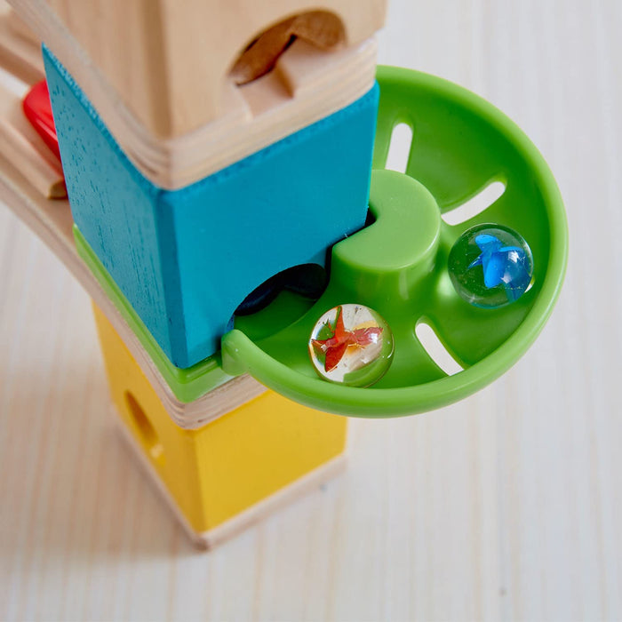 Close up of plastic set pieces and two marbles for the Quadrilla Cliffhanger on a white background