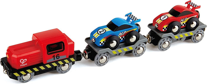 Hape Race Car Transporter includes a red engine, blue and red race cars. The race cars are loaded on the back of the train which has a red and black design with yellow accents.