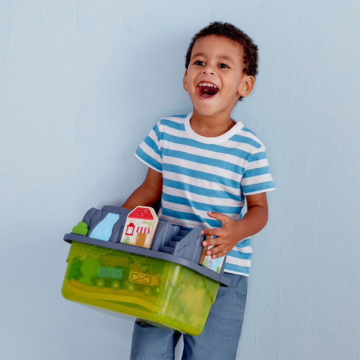 Young boy holding the Railway Bucket Bulider Set against a grey background
