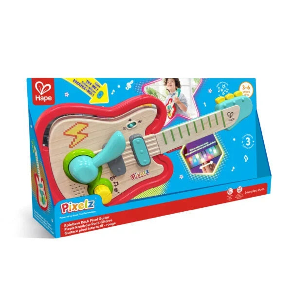 Hape Pixel Rainbow Rock Guitar toy in its original blue and red retail packaging, featuring a wooden guitar with colorful plastic accessories.