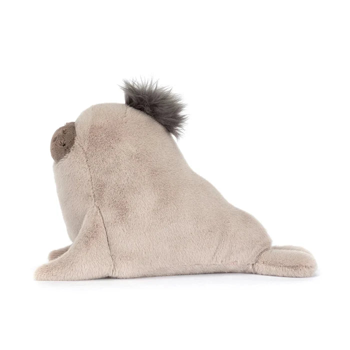 Plush toy resembling a seal with a fluffy tail on a white background