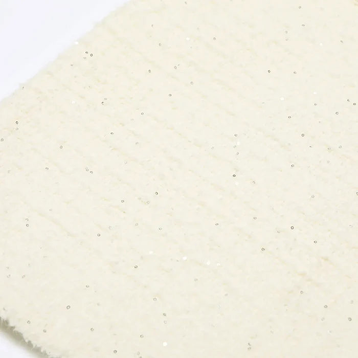 Close-up of a textured beige fabric with a subtle pattern on a white background