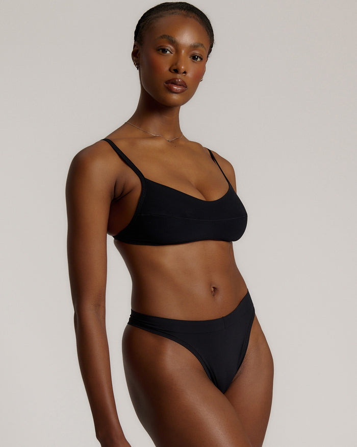Woman wearing black scoop system against a neutral background