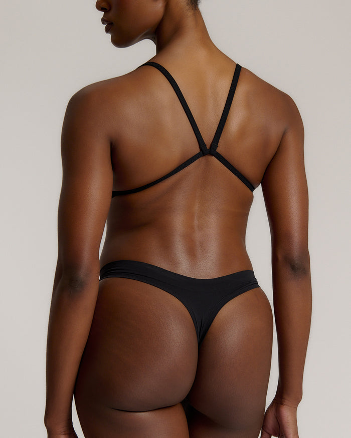 Woman wearing black scoop system against a neutral background
