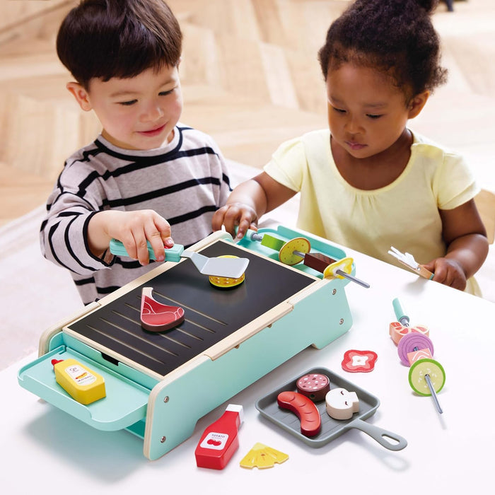 Two children playing with a toy kitchen set on a table.