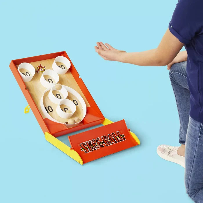 Skee-Ball game on a blue background with a person's arm reaching towards it.