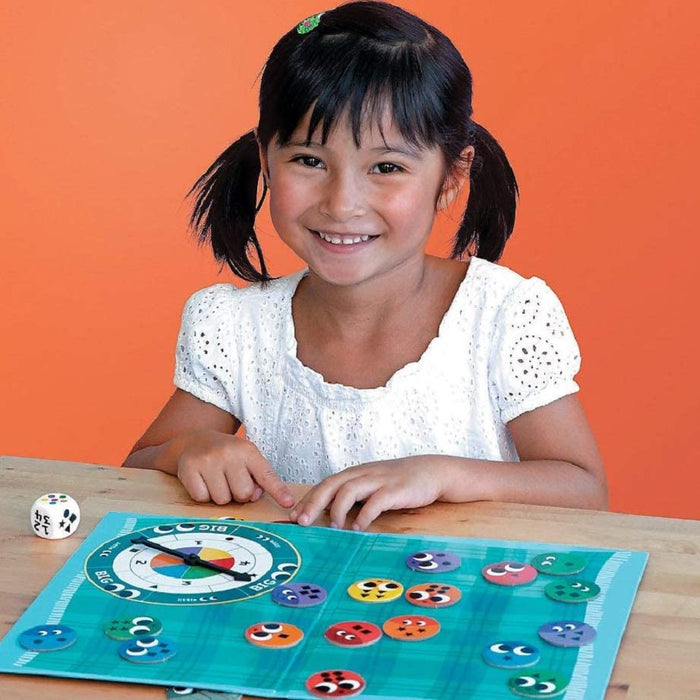 Little girl playing Snug as a Bug in a Rug on a wooden table.