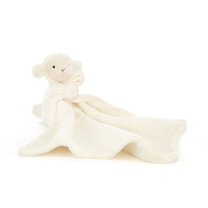 White plush lamb toy with a soft blanket on a white background