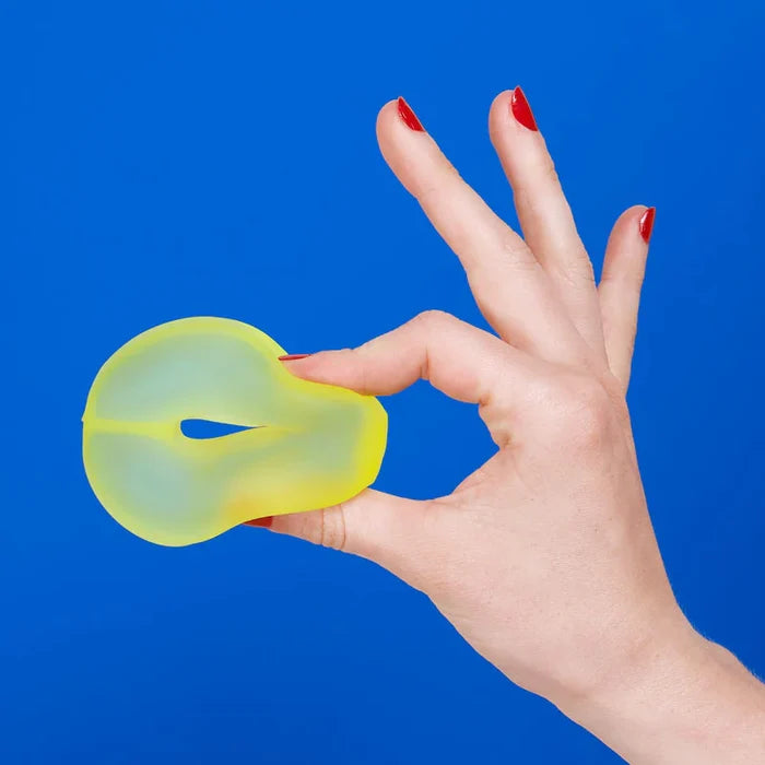 Hand holding a yellow object against a blue background