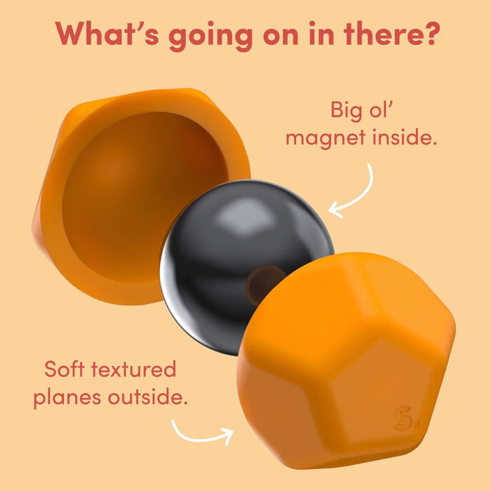 Orange geometric object with a black sphere inside on a beige background