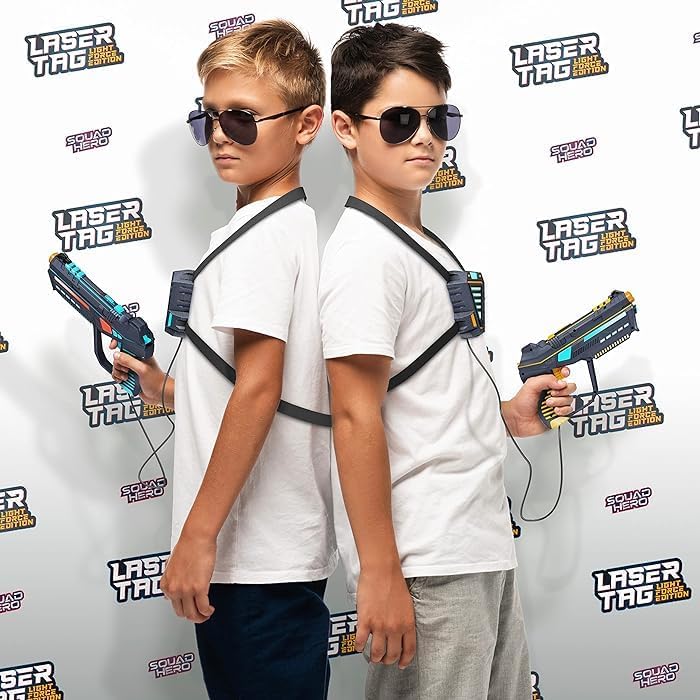 Two children in white shirts with laser tag vests and basters, standing in front of a laser tag branded backdrop.