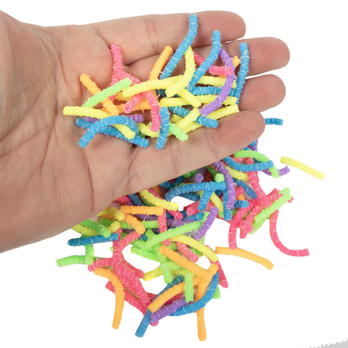 Hand holding colorful Squirmiez against a white background