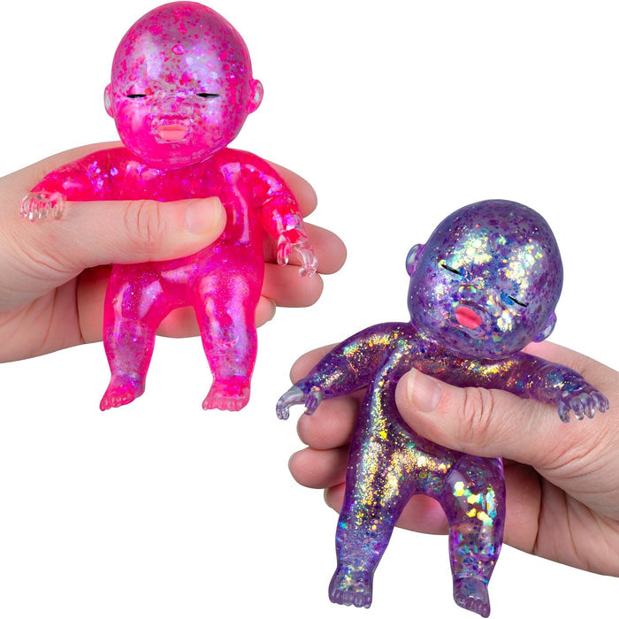 Two iridescent squishy baby dolls, one pink and one purple, held in hands against a white background.