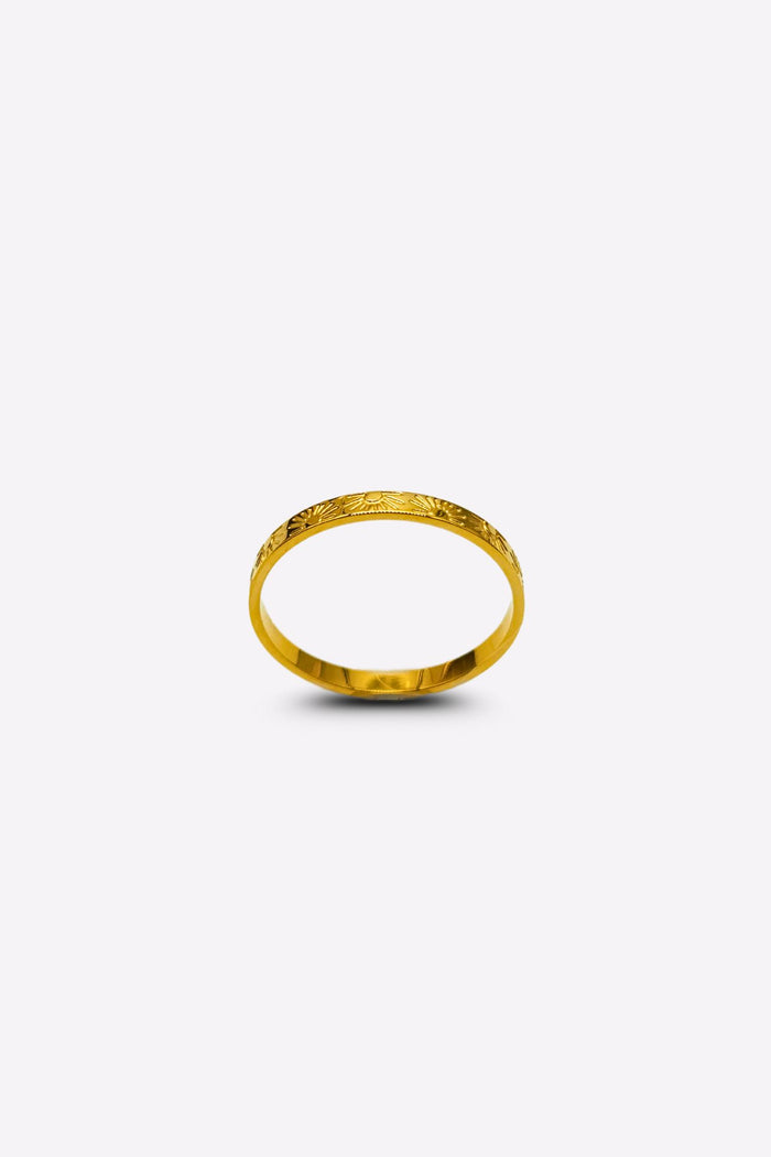 Elegant gold ring featuring sun and ray inscriptions, captured from a front angle on a white background.