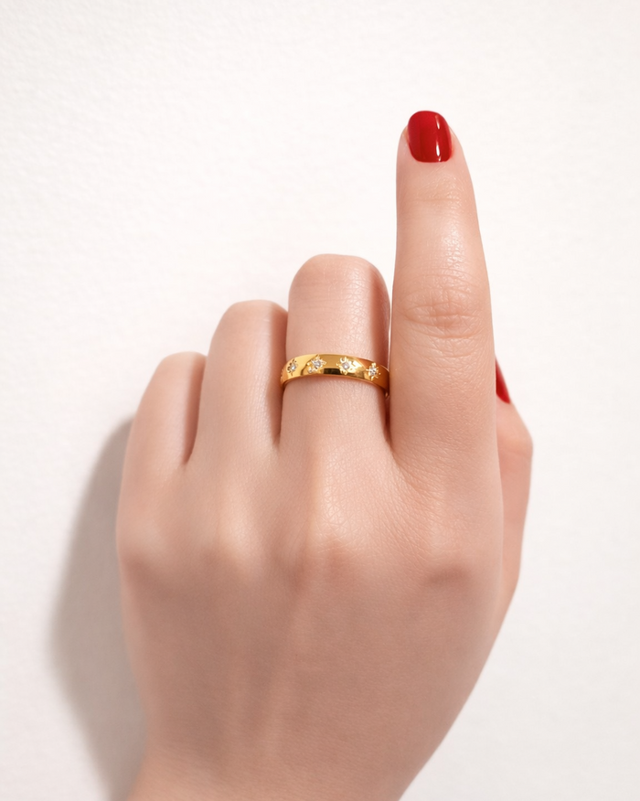 gold gemstone ring star set band on hand model red nails close up