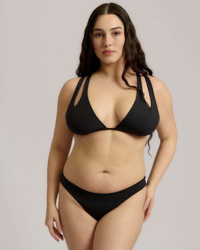 Woman wearing a black bikini against a plain background