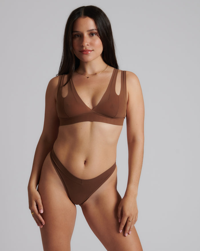 Woman wearing a brown bra against a neutral background
