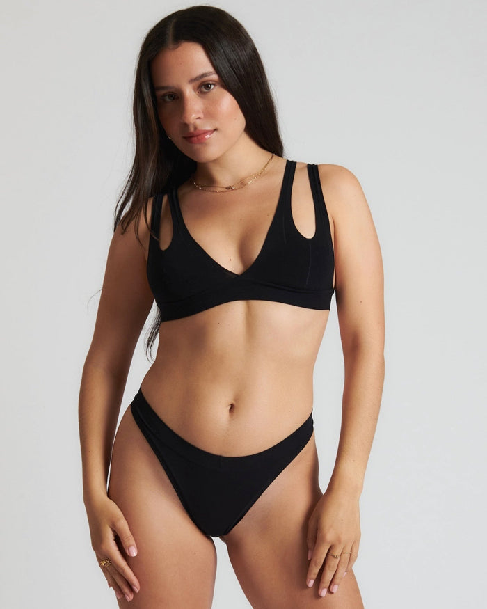 Woman wearing black tee system on plain background