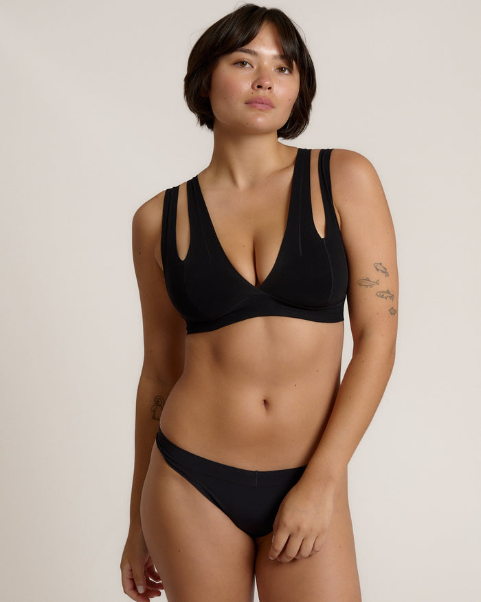 Woman wearing black tee system on plain background