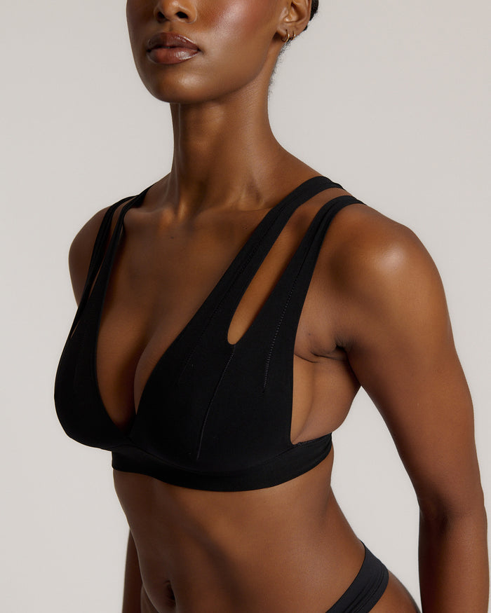 Woman wearing black tee system on plain background