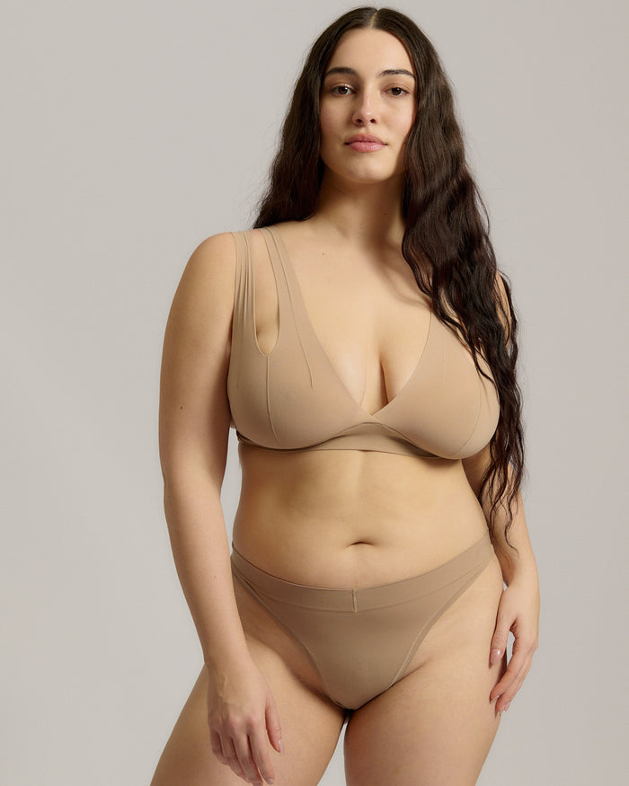 Woman wearing a light tee system against a plain background