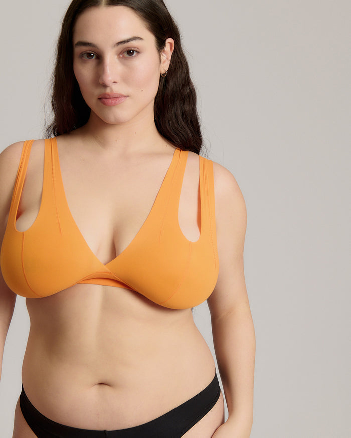 person wearing a tangerine tee system on a plain background