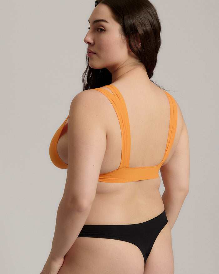 person wearing a tangerine tee system on a plain background