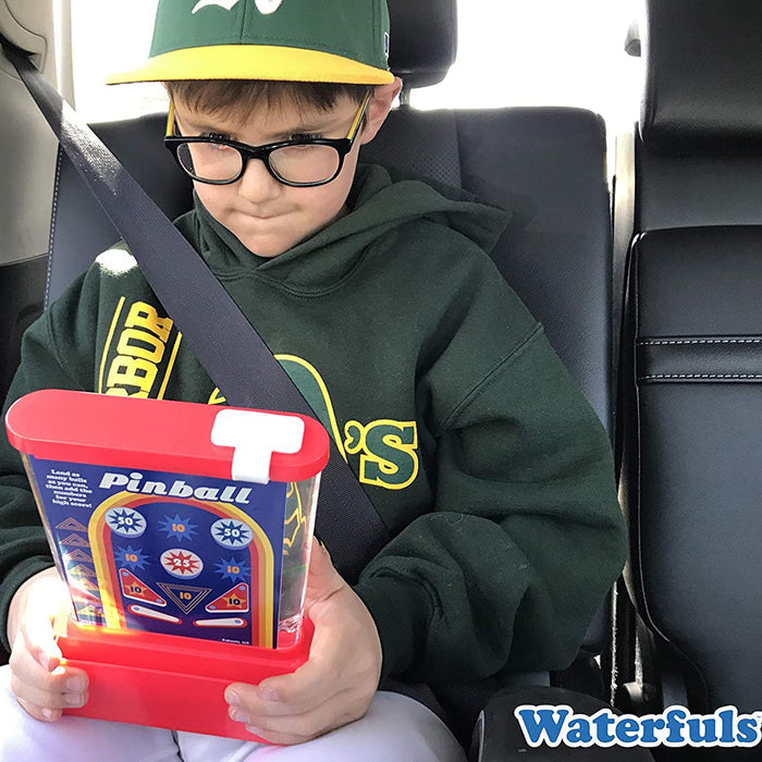 Child in a car seat holding a toy with 'Pinball' text, wearing a green hoodie and cap.