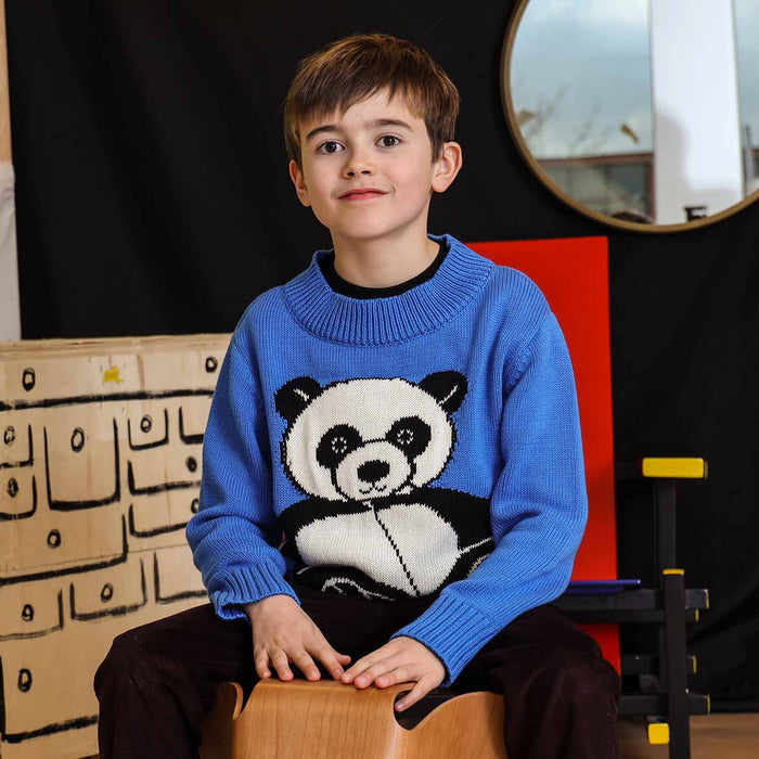 Child wearing a panda sweater while smiling at the camera