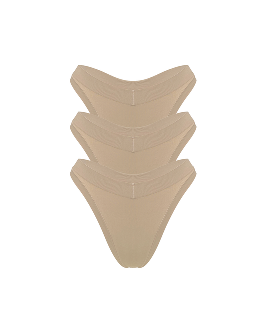 Three stacked nude beige thong underwear stacked on a solid white background.