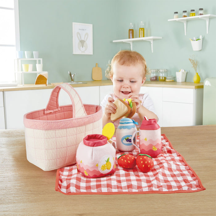 Child playing with a picnic set on a wooden table in a kitchen