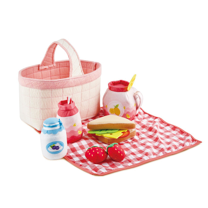 The Toddler Picnic Set with checkered blanket, basket, sandwich and berries on a white background