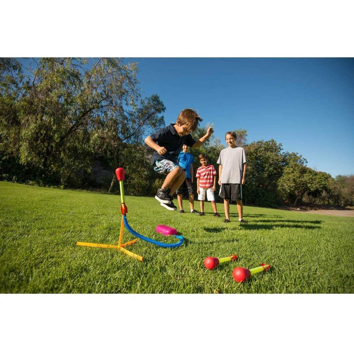 Kids playing on a grass field with stomp rockets