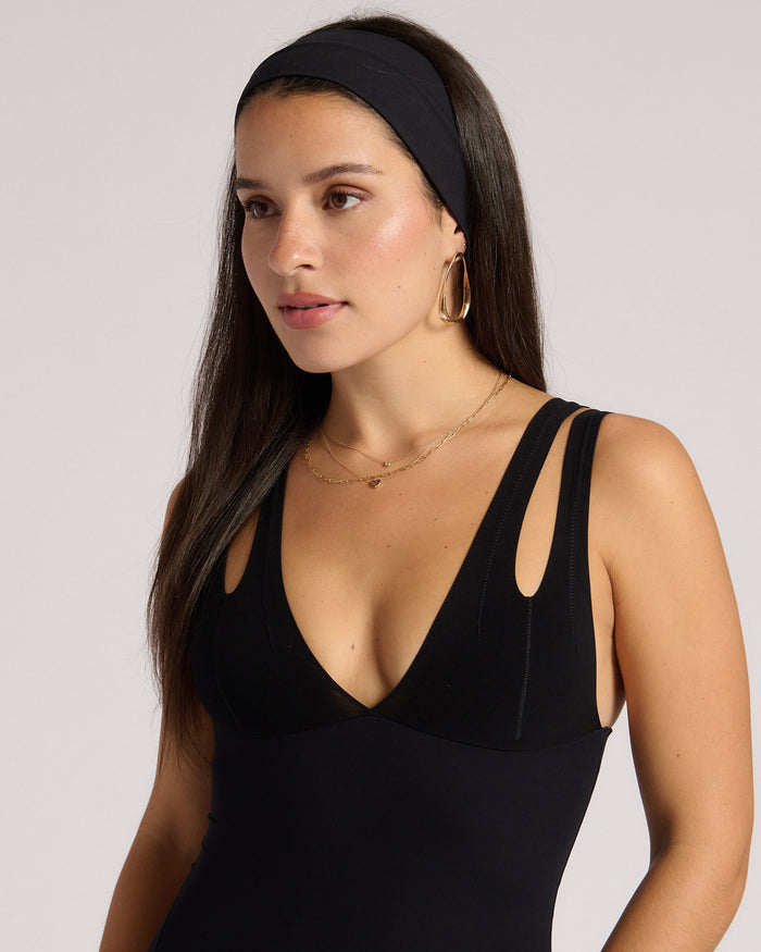 Woman wearing a headband against a plain background