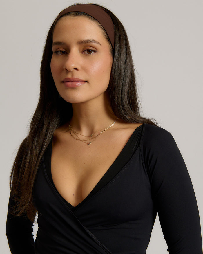 Woman wearing a headband against a plain background