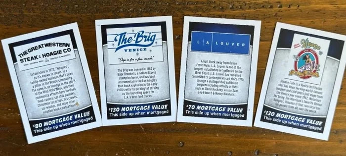 Four mortgage value cards from different companies on a wooden surface