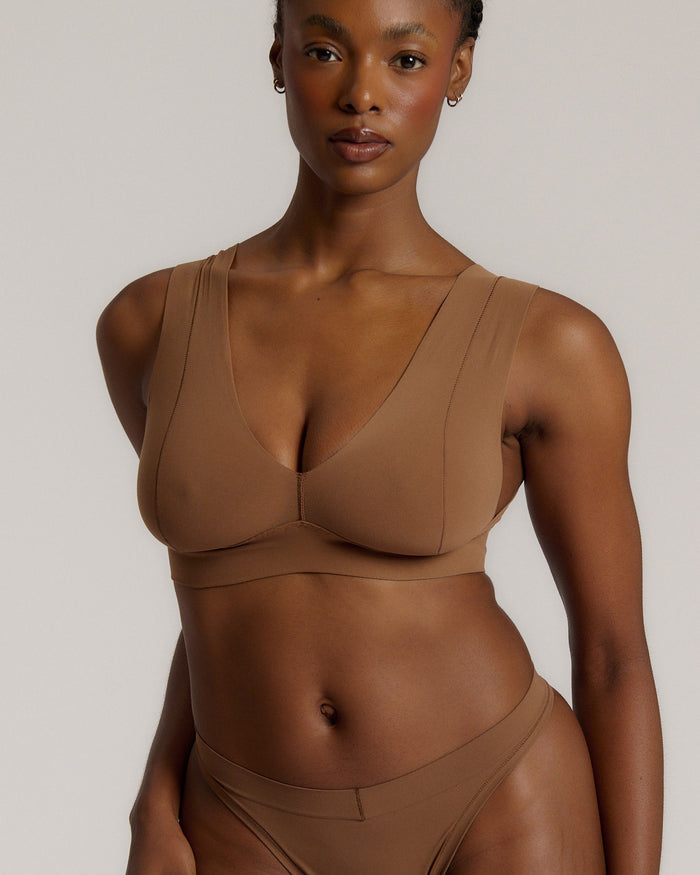 Woman wearing a brown vii system against a plain background