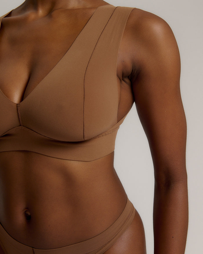 Woman wearing a brown vii system against a plain background
