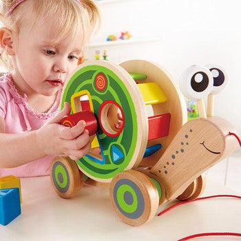 Child fitting shapes into the shell of the walk along snail