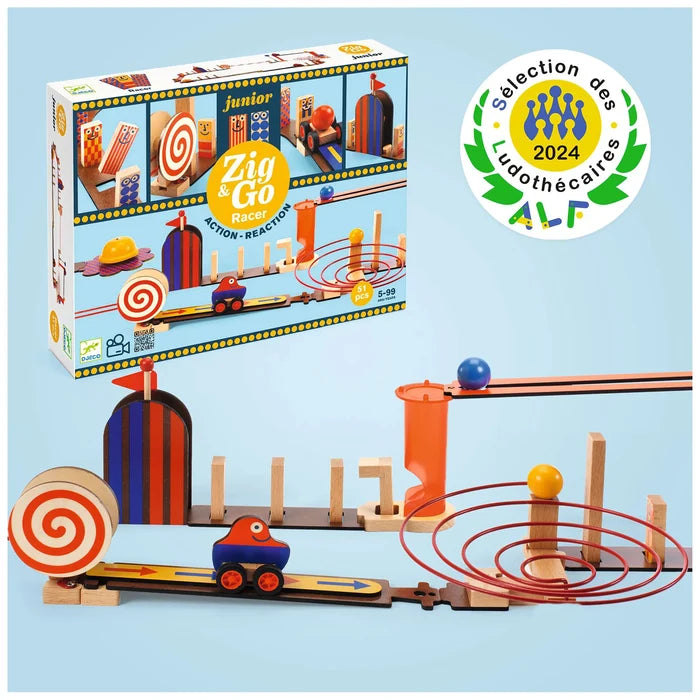 A children's wooden toy set shown with its retail box and assembled tracks on a light blue background. The set includes a small train, ramps, loops, and colorful wooden structures.