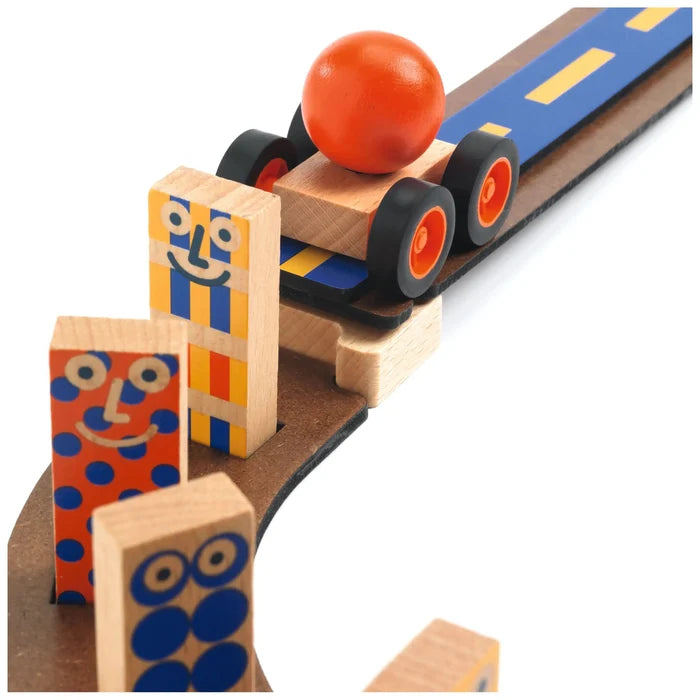 A close-up of a wooden toy train set with a blue and yellow train pulling a red ball, alongside colorful wooden character blocks on a white background.